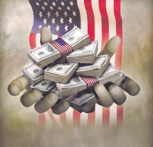 Handfuls_of_dollar_stacks_and_US_flag